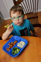 Boy with kiddiebites blue silicone plate with rice and chicken dinner kiddiebites donate a meal to children in need for every plate purchased