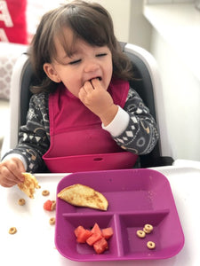 Girl eating on Kiddiebites silicone plum plate